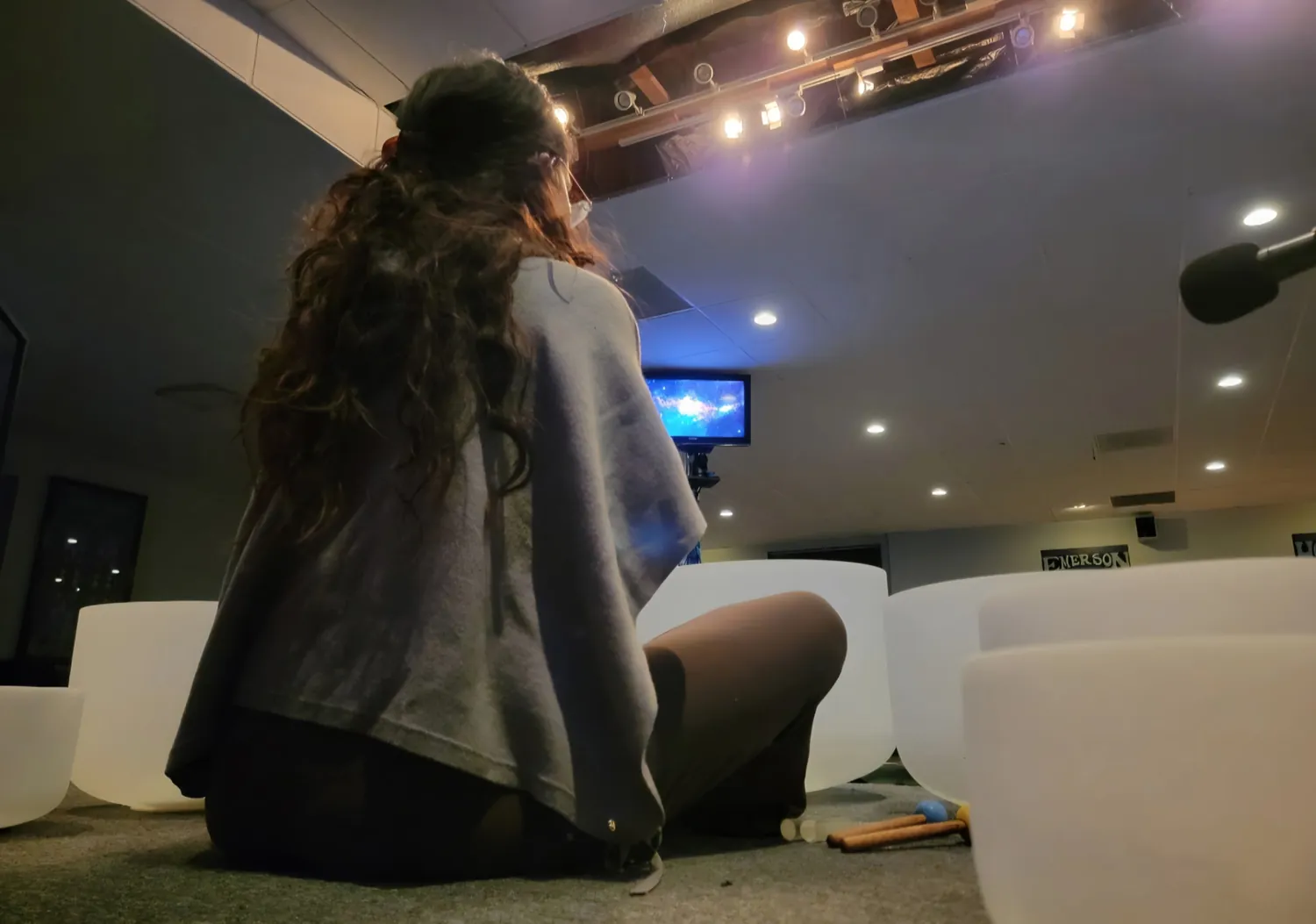 Abby, the person behind Mother Mystica, seated among sound healing bowls